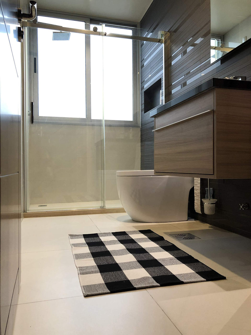Modern bathroom with a freestanding bathtub, checkered rug, and wooden vanity.