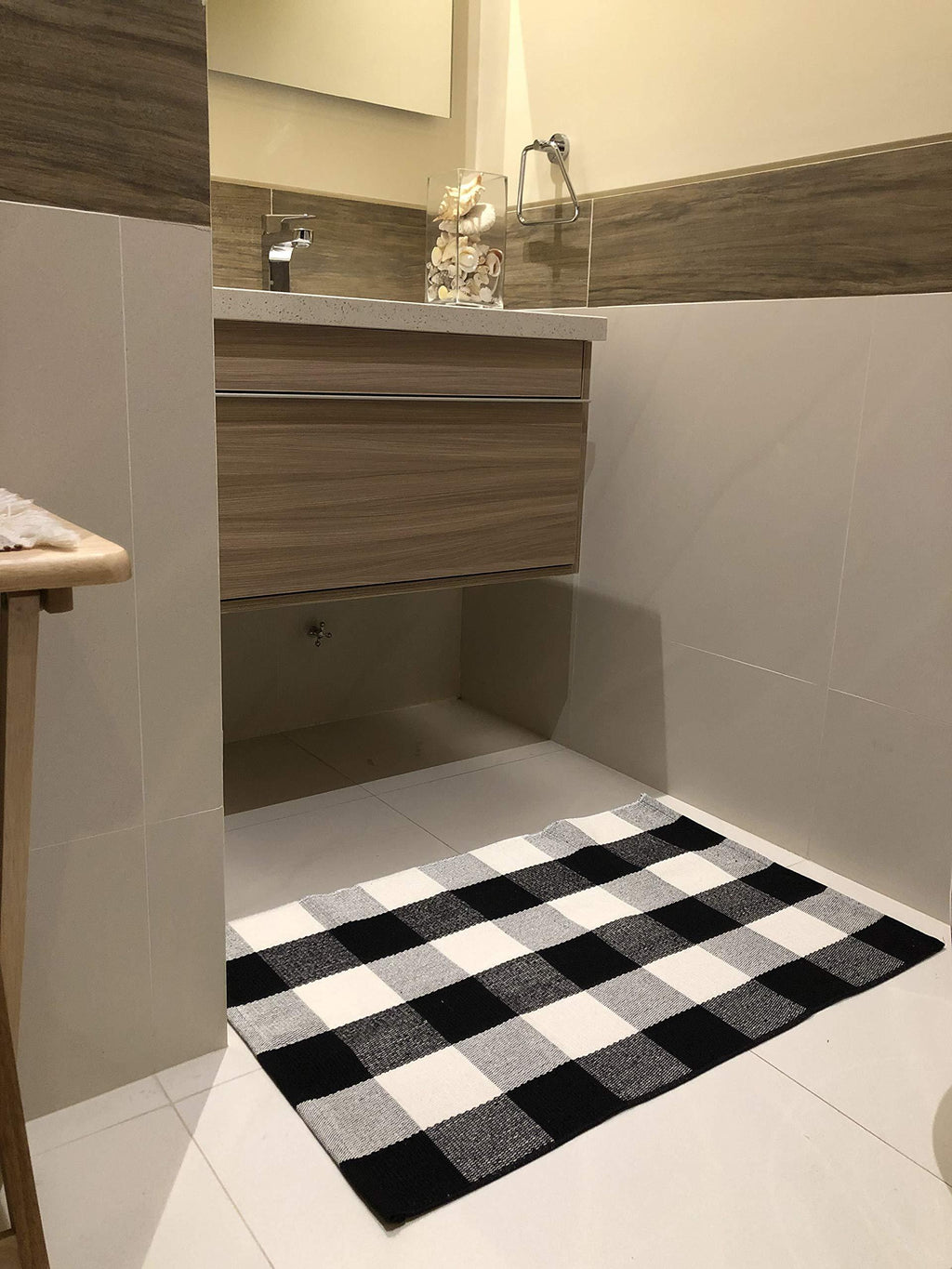 Bathroom with a checkered black and white rug on the floor.