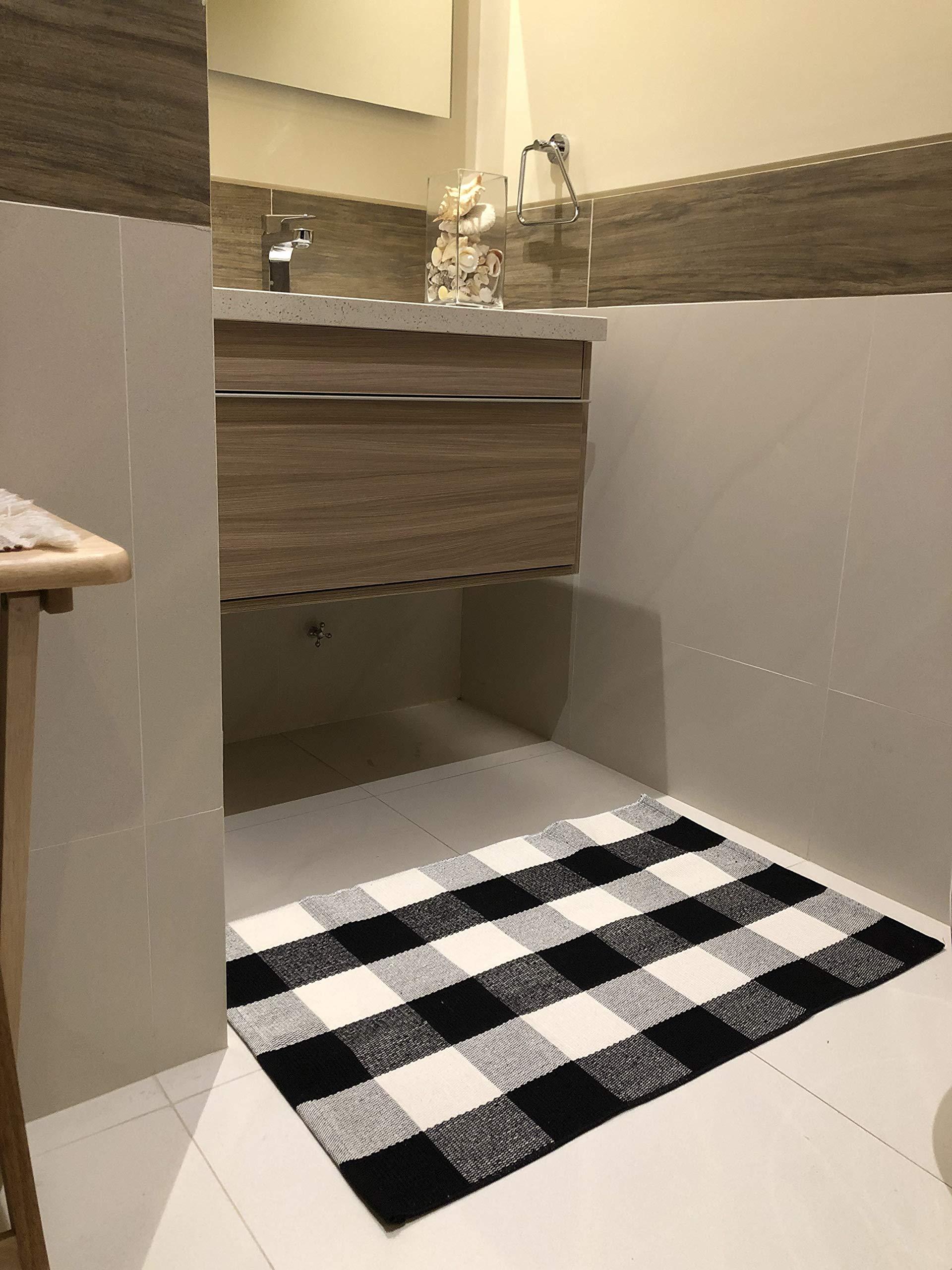 Bathroom with a checkered black and white rug on the floor.