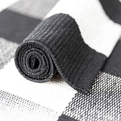 Rolled black and white buffalo plaid cotton rug showing close-up woven texture