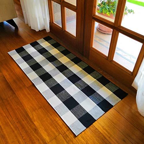Black and white buffalo plaid rug placed on wooden floor in bright room