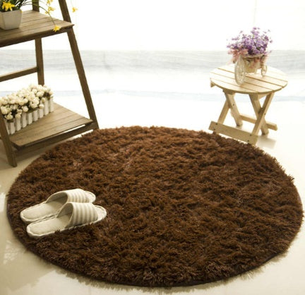 Brown round fluffy carpet placed beside sofa in living room