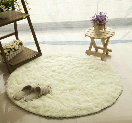Cream round faux fur rug styled in cozy living room