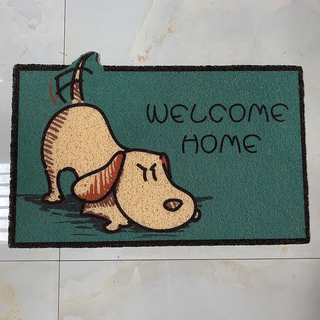 Doormat with a cartoon dog and 'Welcome Home' text on a tiled floor.